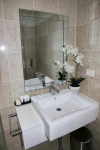 a bathroom with a white sink and a mirror at Mariners Court Hotel Sydney in Sydney +37 photos