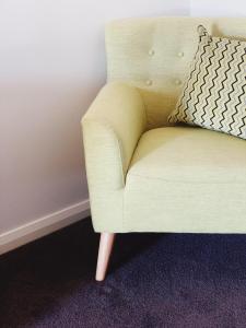 a yellow chair with a pillow on a wall at Red Earth Motel in Broken Hill