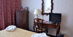 a bedroom with a bed and a television at Volzhskaya Riviera Hotel in Uglich