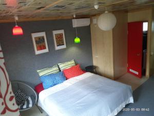 チョロノモスクにあるGuest House Serenaのベッドルーム1室(赤と青の枕が備わるベッド1台付)