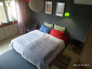 チョロノモスクにあるGuest House Serenaのベッドルーム1室(カラフルな枕付きのベッド1台付)