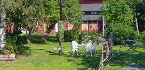 a table and chairs in a yard with a fence at Katariinan Kamari in Raahe
