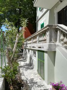 um edifício branco com janelas verdes e uma varanda em AGLI OLEANDRI em Gorizia