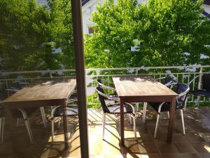 two wooden tables and chairs on a balcony at Ferienwohnung Wiedmann in Tübingen