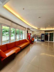 - un salon avec des canapés orange dans une bibliothèque dans l'établissement Better Place Hotel, à Ubon Ratchathani