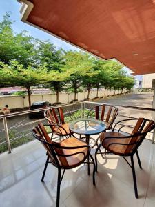 a table and chairs on a balcony with a view of a street at Better Place Hotel in Ubon Ratchathani