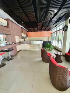 a lobby with tables and chairs in a building at Better Place Hotel in Ubon Ratchathani