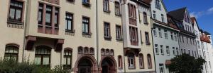 a tall building with many windows on a street at Vorbeischauen in Plauen 2 in Plauen