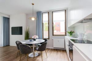 a kitchen and dining room with a table and chairs at Blue Rentyear Apartments in Gdańsk +5 photos