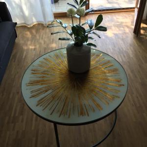 a glass table with a vase on top at Fewo Spectrum in Überlingen