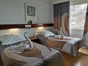 two swan beds in a hotel room with swans on them at Hotel Kemijärvi in Kemijärvi