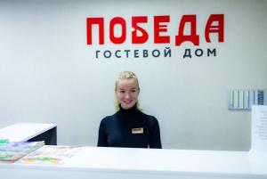 a woman standing behind a counter in front at Mini Hotel POBEDA in Vladimir