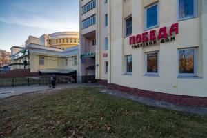 a person walking a dog in front of a hotel at Mini Hotel POBEDA in Vladimir