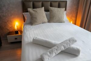 a white bed with two towels on the bottom of it at Apartament Central Radu in Sibiu