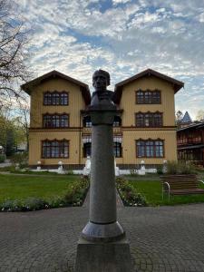 uma estátua de um rapaz num poste em frente a um edifício em Villa OLD POST em Juodkrantė