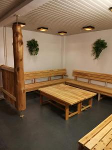 Habitación con bancos de madera y macetas en la pared. en Hotel Kemijärvi, en Kemijärvi