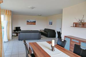 sala de estar con mesa y sofá en Ferienwohnung Bergblick Xanten, en Xanten