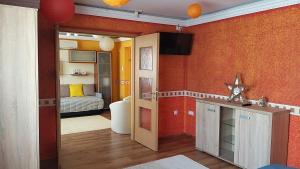 Édenkert Apartmanház في كيسفاردا: غرفة معيشة مع جدران برتقالية وغرفة نوم