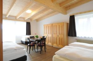 ein Schlafzimmer mit einem Tisch und Stühlen in einem Zimmer in der Unterkunft B&B Hotel Heidi in Toblach