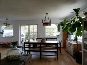 una sala da pranzo con tavolo, sedie e finestre di Fancy Luxury Home In Former Tavern a Gmunden