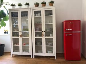 un frigorifero rosso accanto a un mobile bianco con stoviglie di Fancy Luxury Home In Former Tavern a Gmunden