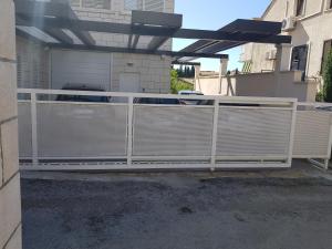 a white fence in front of a garage at Apartments Laus in Dubrovnik