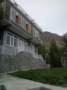 a large house with white railings on the side of it at Hunza Holiday Inn in Baltit