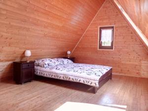 een slaapkamer met een bed in een houten hut bij Góralski dom w Parku Krajobrazowym in Brenna