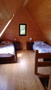 a attic room with two beds and a window at Góralski dom w Parku Krajobrazowym in Brenna