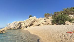 a sandy beach next to the water on a cliff at Villa Marina in Omiš