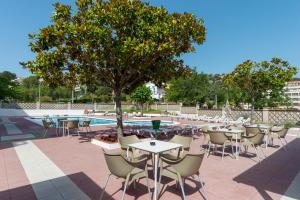 a patio with tables and chairs next to a pool at BLUESEA Continental in Tossa de Mar