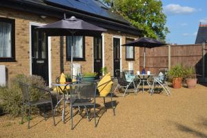 a group of chairs and tables with umbrellas at Epicsa - Family & Corporate Stay MEWS APARTMENTS with FREE parking in Cambridge