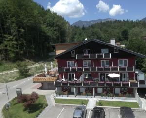 ein großes rotes Gebäude mit Balkonen und Autos auf einem Parkplatz in der Unterkunft Pension Waldesruh in Bad Ischl