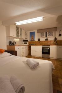 a kitchen with two white beds in a room at Studio Apartment Nihar in Cres