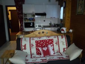 eine Couch mit einer Decke drauf in der Küche in der Unterkunft Appartement les Carroz d'Arraches in Les Carroz d'Araches