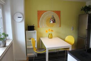 a kitchen with a white table and yellow chairs at Ferienwohnung am Stemberg in Detmold