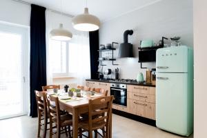 una cucina con tavolo, sedie e frigorifero di BOTTASSO17 Guest House a due passi dal mare a Terracina