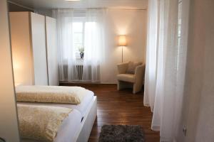 a bedroom with two beds and a chair and a window at Ferienwohnung am Stemberg in Detmold