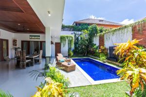 a swimming pool in the backyard of a house at MasBro ART Villas in Seminyak
