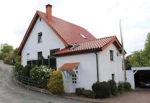 a white house with a red roof at Ferienwohnung am Stemberg in Detmold
