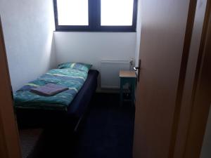 a small bed in a room with a window at Monteurunterkunft Oberaula in Oberaula