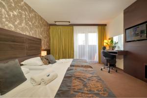 Hotel Centrum في نيترا: غرفة فندقية بسريرين ومكتب