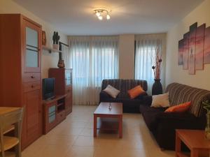 uma sala de estar com um sofá e uma televisão em Apartamento Las Pontigas em Posada de Llanes