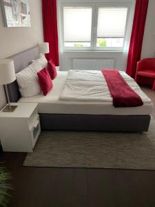 Un dormitorio con una cama con almohadas rojas y una ventana en Hotel zum Postwagen en Gevelsberg