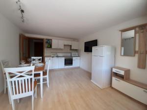 a kitchen with a table and a white refrigerator at Apartament Tatiana in Rogaška Slatina