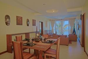 a living room with a dining table and a couch at Cowrie Shell Beach Apartments Official in Bamburi