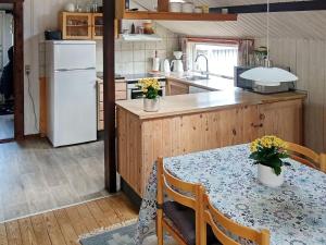 Alsにある6 person holiday home in Hadsundのキッチン(テーブル、白い冷蔵庫付)
