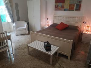 1 dormitorio con 1 cama, 1 mesa y 1 silla en B&B Casa Laganà, en Reggio Calabria