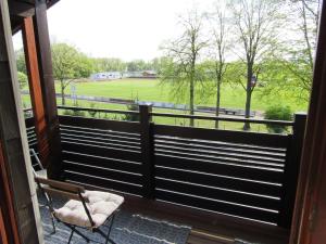 a balcony with a chair and a view of a field at Wohlfühlwohnung in Ergolding in Ergolding