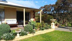 Austiny Bed and Breakfast Victor Harbor في فيكتور هاربور: شرفة منزل مع حديقة